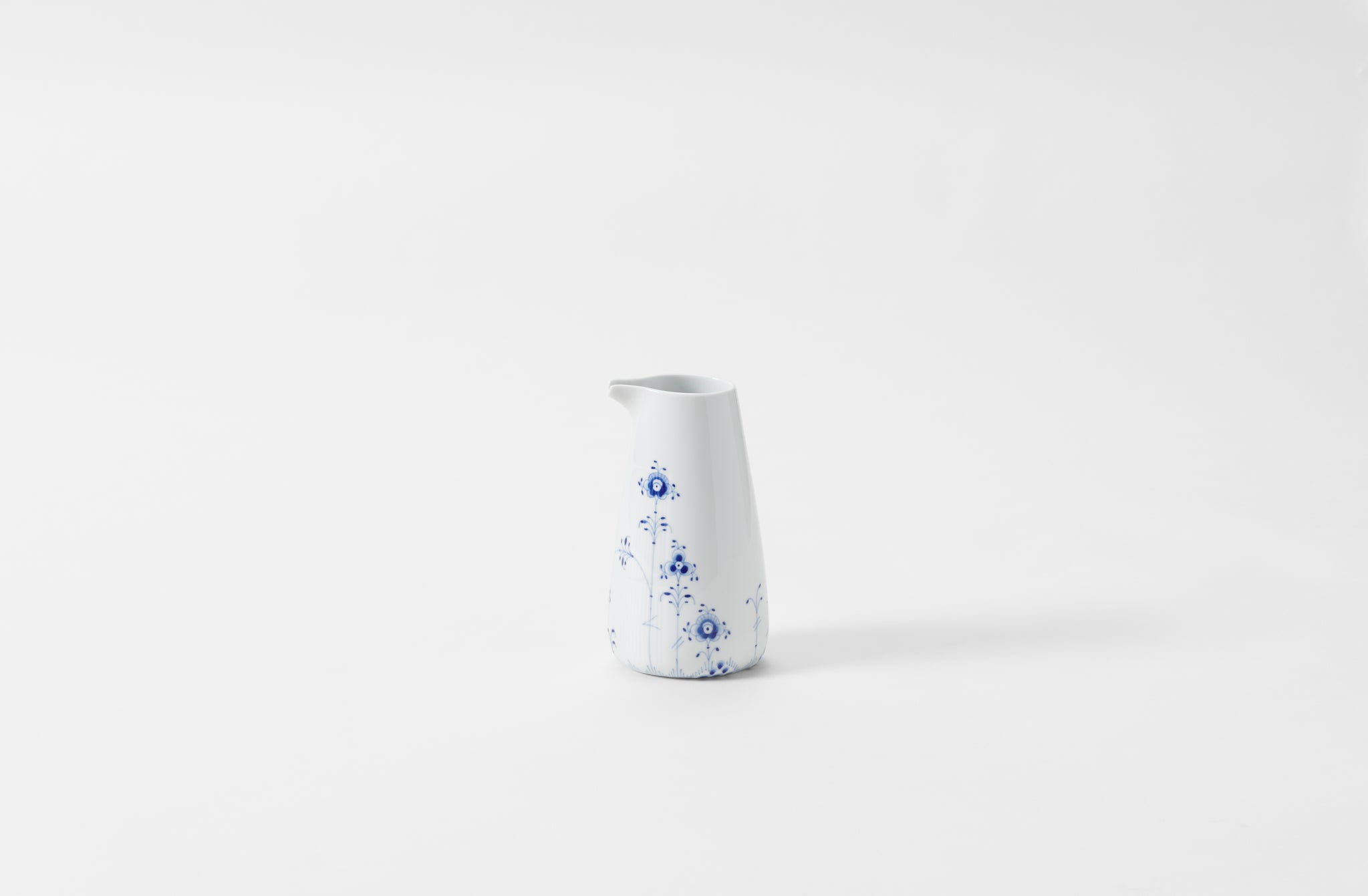 A white and blue floral patterned porcelain jug on a white background.