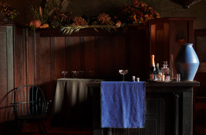 bar scene in old building with silver and crystal barware set on a boxwood navy linen runner