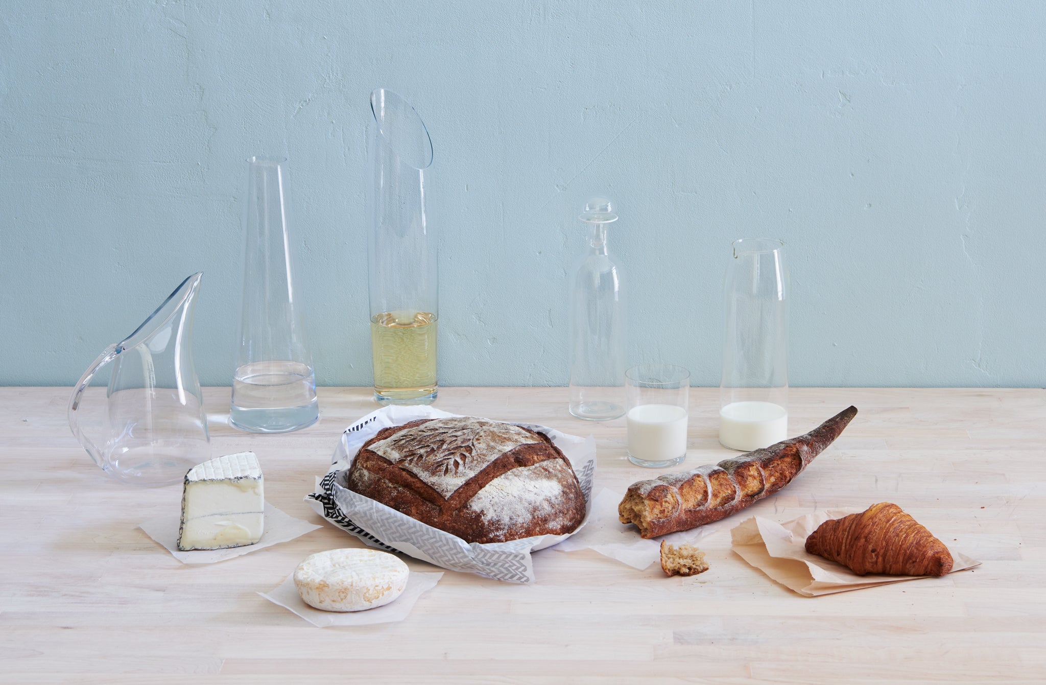 Deborah-Ehlich-Decanters-and-a-Glass-with-Food-on-butcherblock-with-blue-plaster-background