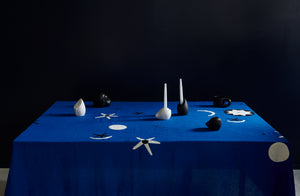 malaika cosmic embroidered linen tablecloth set with carol leskanic black and white candleholders and sculptures