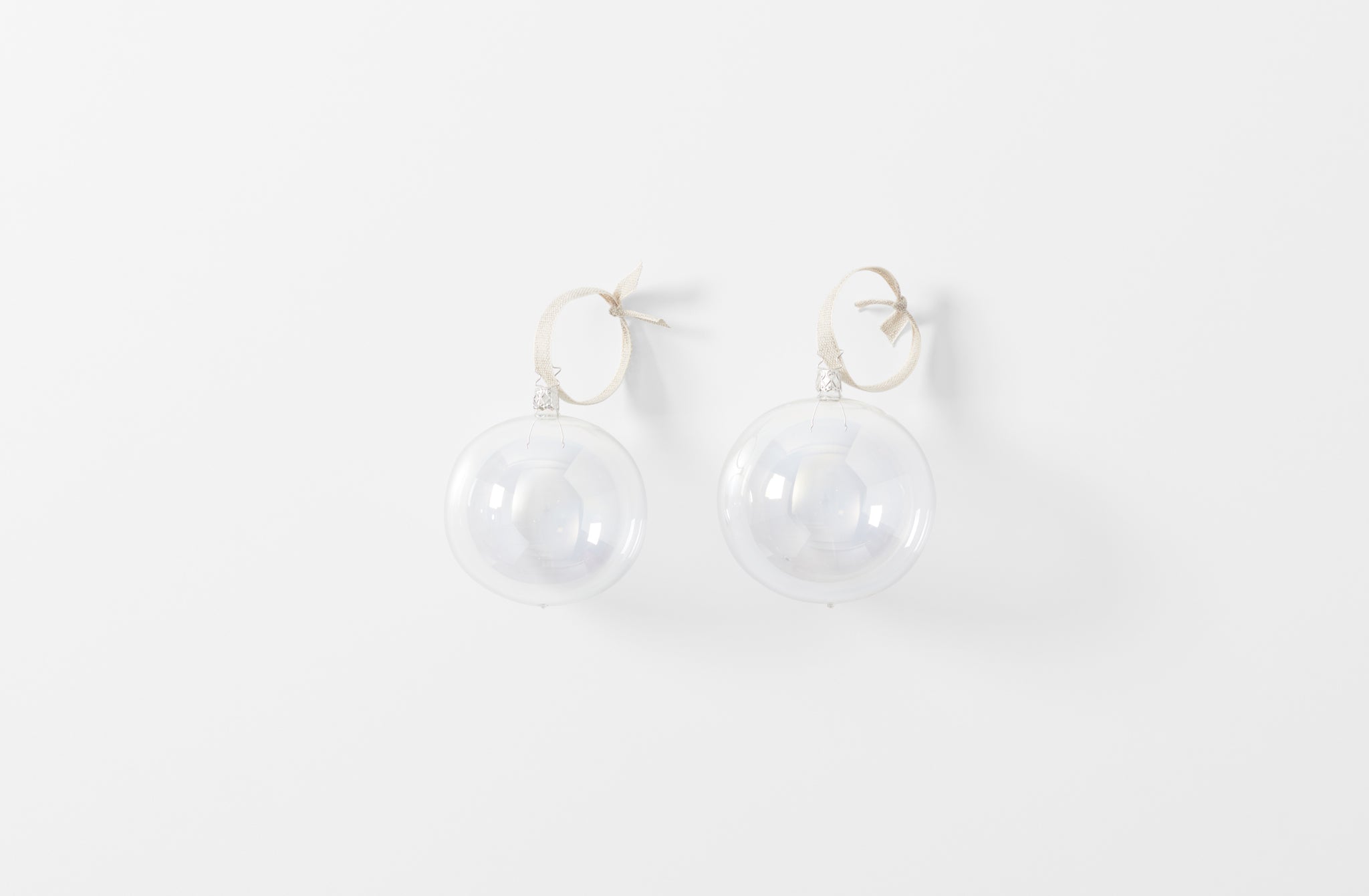 iridescent large clear mouth blown glass ornament shown as a set of two with linen ribbon loops