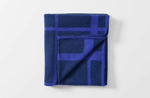 cashmere and wool throw blanket inspired by le corbusier lc2 in dark navy and purple shown folded with one corner turned up