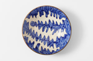malaika hand painted ceramic matisse patterned serving bowl in blue and white on brown shown from overhead