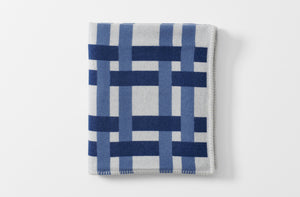 milk and cobalt colored grid cashmere and wool throw blanket with pig stitch edge shown folded