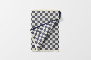 navy jacquard checkerboard runner with fringed edges shown folded with one corner turned up
