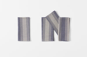 four tensira navy and natural tartan plaid napkins shown folded