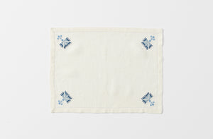 malaika ottoman blue on cream embroidered placemat shown from overhead